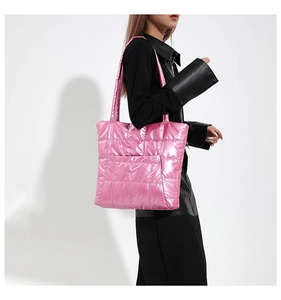 Quilted tote bag in pink metallic finish shown worn over the shoulder by a model