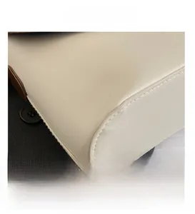 Détail du cuir blanc cassé lisse avec coutures précises et bords peints en marron foncé