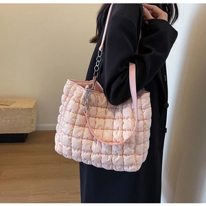 Close-up of pink quilted tote bag with metallic chain and air-puffy texture detail