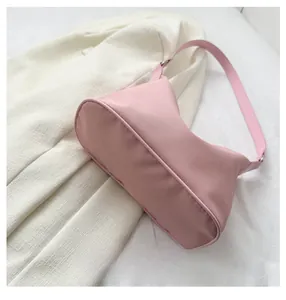 Detailed bottom view of pink nylon crescent bag showing reinforced oval base and stitching