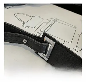 Detail of black leather shoulder strap featuring neat stitching and silver metal buckle