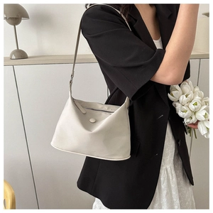 Detail view of the sleek cream white nylon shoulder bag styled with a minimalist outfit