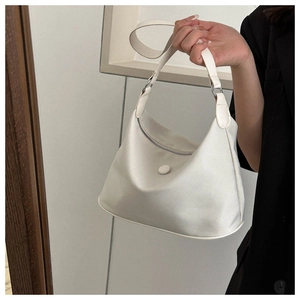 Close-up of a white waterproof nylon crescent shoulder bag with silver hardware details