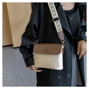 Détail d'un sac bandoulière contrasté avec large bandoulière tissée aux motifs rétro