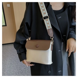 Détail du sac bandoulière bicolore vintage avec large sangle au motif ethnique