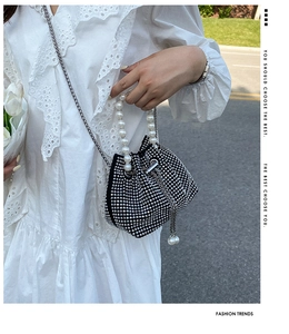 Borsa a secchiello nera con strass, manico di perle e dettagli nappe metalliche