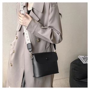 Détail du sac bandoulière noir avec large sangle au motif géométrique rétro