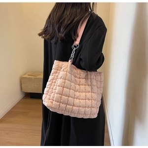 Detail of pink quilted tote bag showing bubble texture and silver metal chain strap