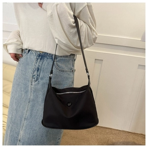 Detail of waterproof nylon shoulder bag with silver zipper and matte black texture