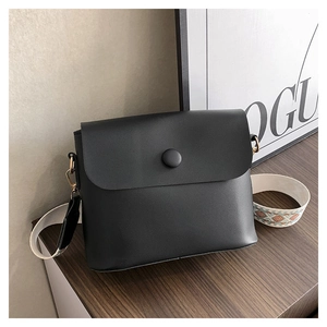 Détail du sac bandoulière noir avec une large sangle brodée de style bohème chic