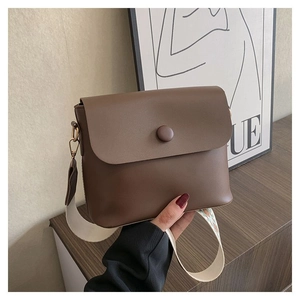 Détail d'un sac bandoulière marron en similicuir avec bandoulière large ethnique
