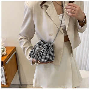 Vista laterale di una mini borsa a secchiello nera con strass argentati e tracolla a catena