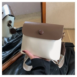 Détail du sac bandoulière bicolore avec large sangle tissée en jacquard géométrique
