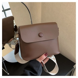 Vue détaillée du sac bandoulière en cuir marron foncé avec sangle ethnique large