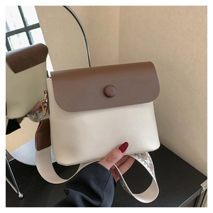 Détail de sac bandoulière avec sangle ethnique brodée et design bicolore marron