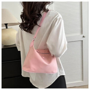 Pink nylon hobo bag shown cross-body on a model in a minimalist modern interior setting