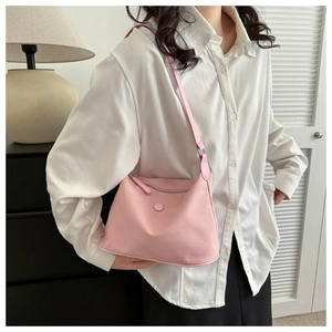 Detail of pink waterproof nylon dumpling bag showing lightweight fabric and silver zipper