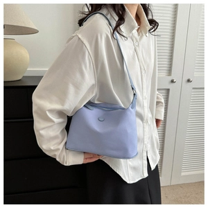 Light blue nylon dumpling bag shown styled on a model wearing a white shirt
