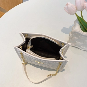 White quilted tote bag with multi-layer interior and gold chain strap in top view