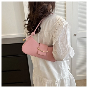 Detailansicht der rosa Baguette-Tasche mit goldener Metallleiste und geknotetem Schultergurt