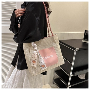 Detail of woven straw tote bag with pink leather Summer patch and floral scarf decor