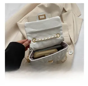 Detailed interior view showing white quilted crossbody bag holding a phone and wallet