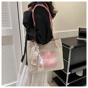 Close-up of woven tote bag with pink Summer logo and decorative floral silk scarf
