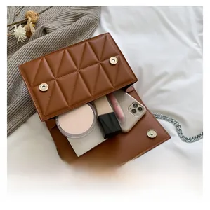 Detail showing internal capacity of the brown quilted crossbody bag with daily essentials