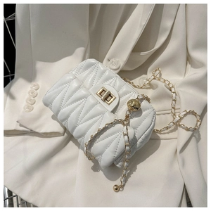 Detail of white quilted crossbody bag with golden chain and adjustable ball clasp