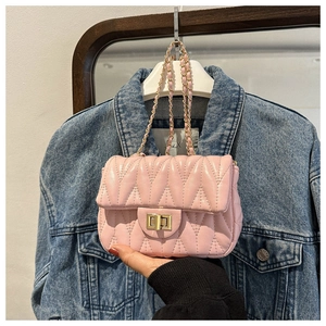 Close-up of pink quilted crossbody bag with gold chain strap and twist lock detail