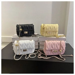 Close-up of quilted crossbody bags in four colors with gold chain straps and ball charms