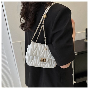 Close-up of a white quilted crossbody bag with gold chain and adjustable metal ball buckle