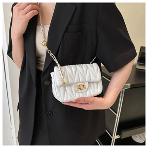 Detail of white quilted crossbody bag with golden chain and adjustable ball buckle