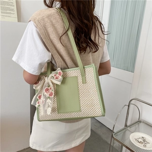 Borsa tote in paglia e pelle verde e beige con un fiocco di pizzo a fiori rosa