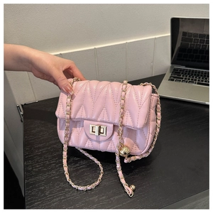 Detail of pink V-quilted leather chain bag with golden swivel lock and metal strap