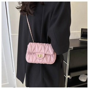 Detail view of pink quilted crossbody bag with V-shaped stitching and gold chain