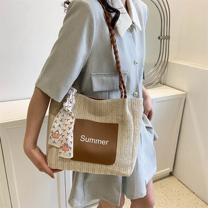 Beige woven tote bag with brown Summer patch and silk scarf shown on a model's shoulder