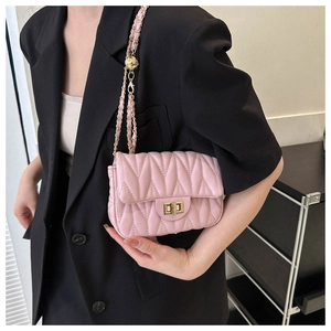 Detail of pink wavy quilted mini bag with gold chain strap and adjustable ball slider