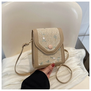 Detailed embroidery on woven small crossbody bag with floral patterns and leather trim