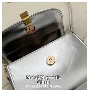Close-up of the premium golden magnetic snap closure on a silver metallic crossbody bag