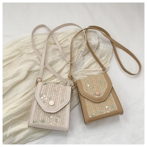 Detail of floral embroidery and straw weave on cream and khaki crossbody phone bags