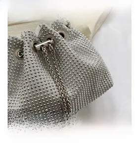 Close-up of sparkling silver rhinestone bucket bag with metal chain strap details