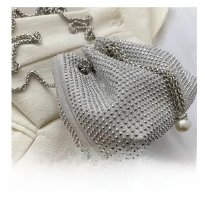 Detail of silver rhinestone bucket bag with metal chain strap and pearl charms