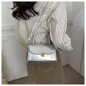 Silver mirror crossbody bag with gold buckle shown on a model for daily styling