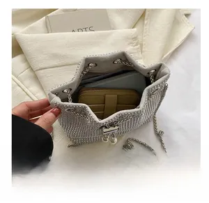 Top view of silver rhinestone bucket bag showing spacious interior with wallet and notebook