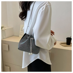 Detail of silver rhinestone bucket bag with pearl drawstring and metal chain strap