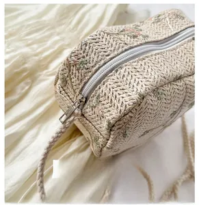 Detail of smooth silver zipper on woven heart-shaped bag with floral embroidery