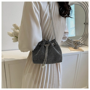 Detail of a sparkling rhinestone bucket bag with silver chain and pearl drawstring details