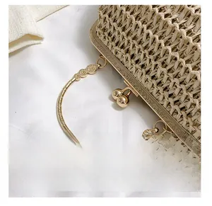 Close-up of handwoven straw handbag with vintage floral engraved metal frame and round handle