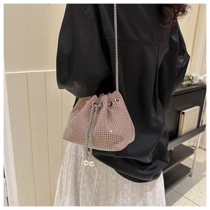 Close-up of pink rhinestone bucket bag with silver chain and pearl drawstring charms